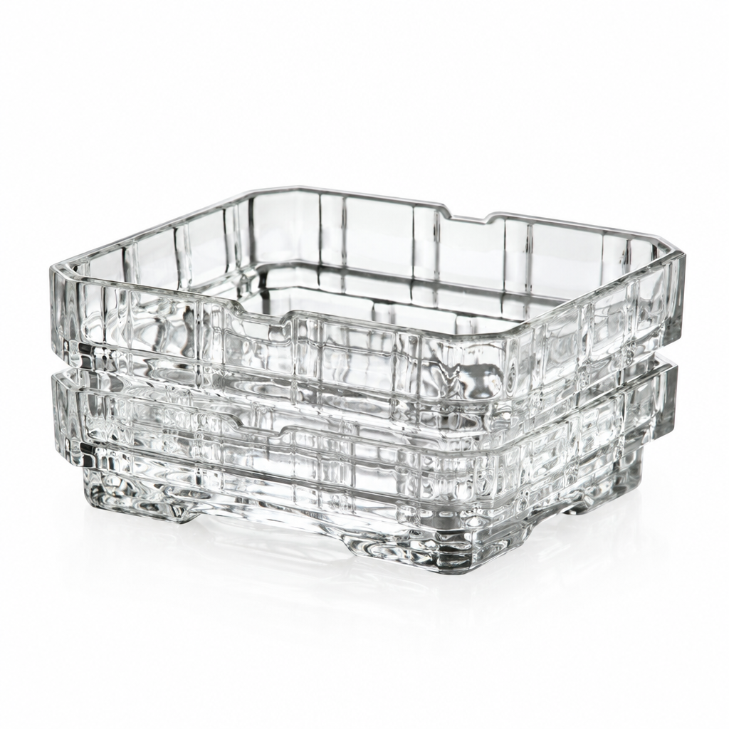 Stacked clear square shallow dishes with patterned sides, viewed at an angle
