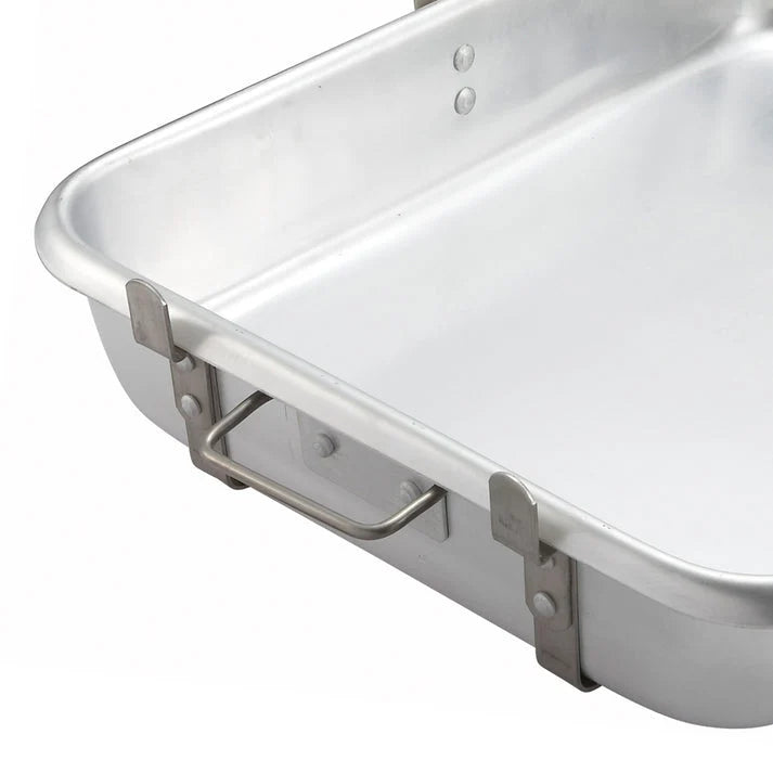 Close-up of a silver-colored rectangular roasting pan showing its side handle, rivets and rolled rim