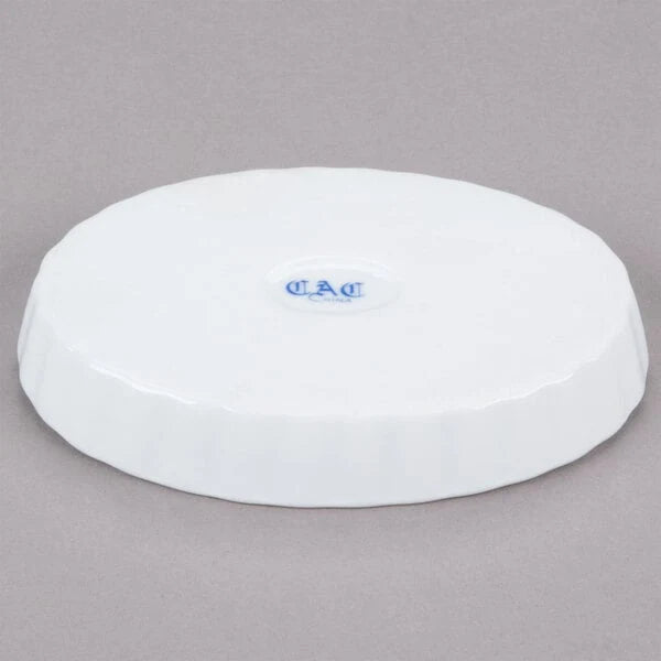 Underside of a white oval dish with a blue maker's mark